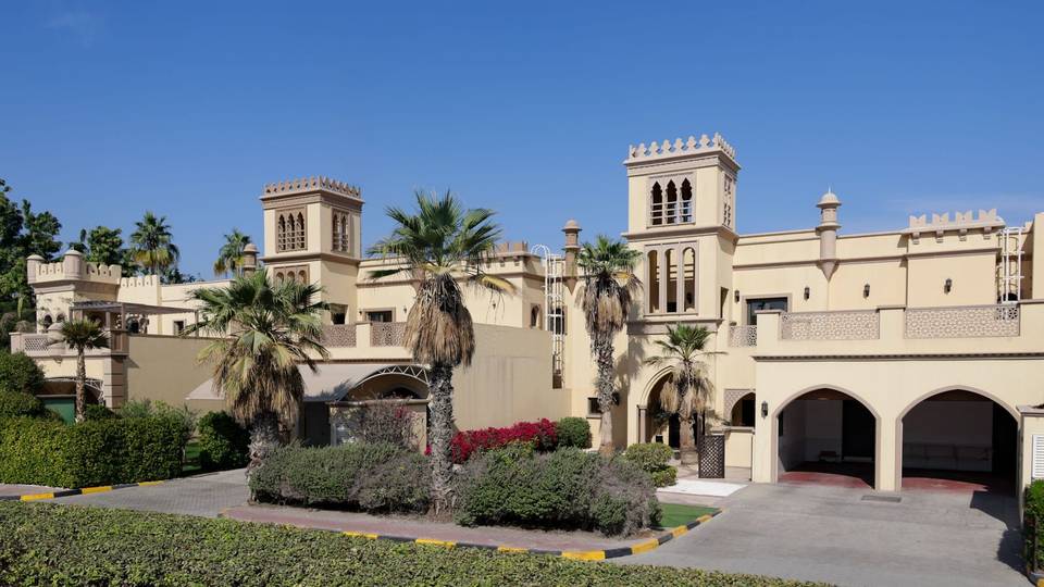 فيلا كبيرة بطابع عربي تحيط بها أشجار النخيل وحديقة